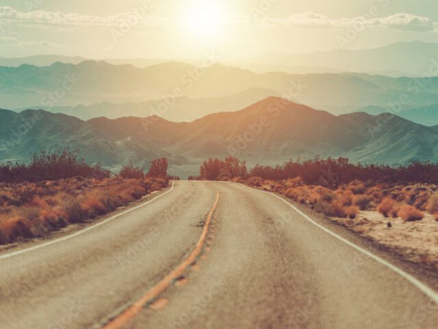 Scenic Mojave Desert Highway Travel During Sunset. California, United States of America. Panoramic Photo.