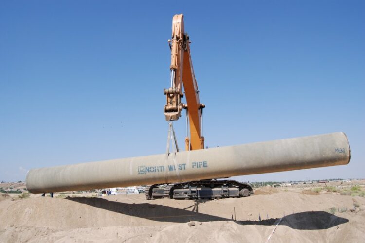 Crane lifting a pipe