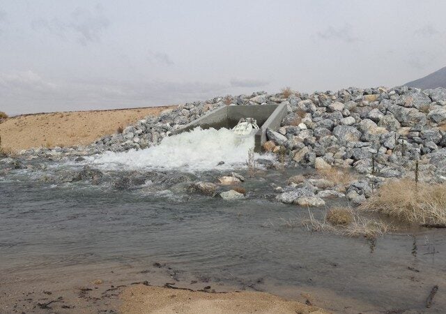 Water rushing from pipe outlet surrounded by rocks